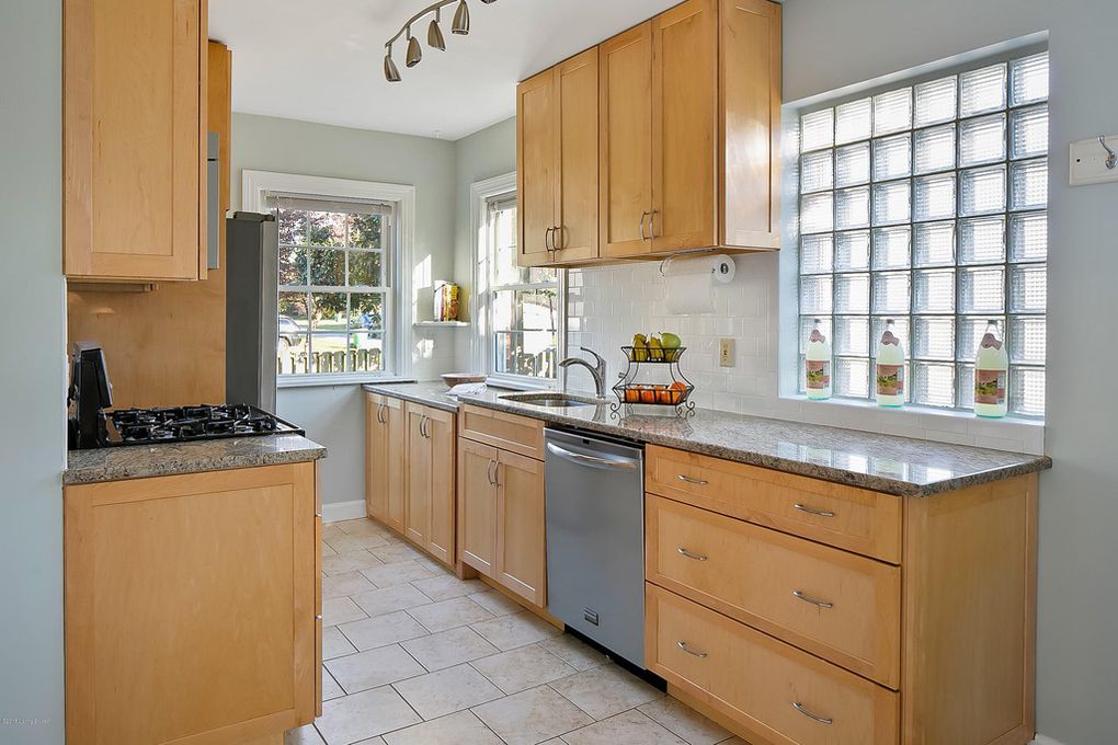 Louisville Kentucky Home Staging, Galley Kitchen, Granite Countertops, Tile Flooring, Stainless and Black Gas Range, Stainless Steel Appliances, Subway Tile, Chrome Fixtures, Glass Block Window