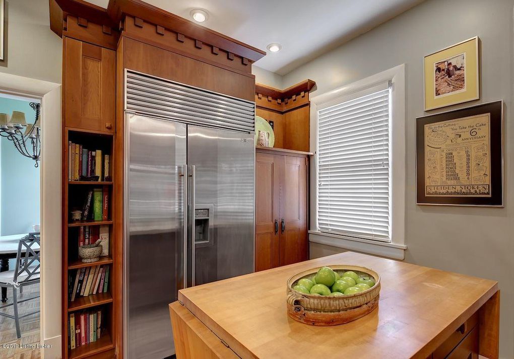 craftsman-style kitchen cabinets, sub-zero refrigerator, dental molding, butcherblock island, built-in bookshelves