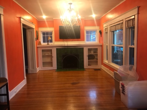 fireplace, white cabinets, hardwood floors, empty dining room, empty living room